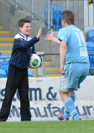 Allan Jenkins celebrates with ball boy Brendan McDonnell after opening the scoring against Dungannon. Picture: Press Eye.