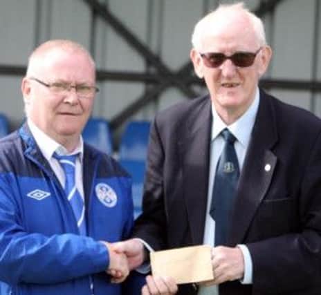 MULDOON AND THE TOON. Ollie Muldoon, President of Ballymoney Utd FC, who sponsored Utd's home game on Saturday, pictured  presenting a cheque to Club Chairman, Noel Lamont.INBM35-13 028SC.