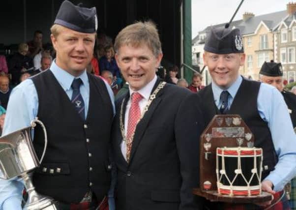 Pipe Major Arnold Mitchell and tenor drummer Darren Crooks from Ballybriest Pipe Band pictured receiving the Champion of Champion trophies for best band and best drum corp in grade 3A from the Chieftain of the Gathering, Councillor Mark Fielding (Deputy Mayor of Coleraine Borough Council) at the North West Pipe Band & Drum Major Championships and RSPBANI Champion of Champions at Ramore Head, Portrush on Saturday 24th August.