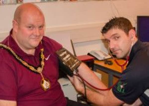 Fitness instructor Kevin Lavery from Waves Leisure Complex. in Lurgan checks out Mayor Mark Baxter before he embarks on his new  fitness regime