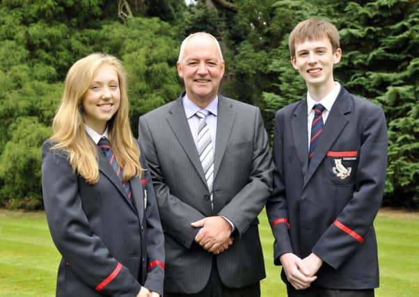 Mr Trevor Robinson, principal of Lurgan College congratulates Kathryn Corr and Gareth Hutchinson who gained 12 A* or A grades at GCSE. INLM35-107gc