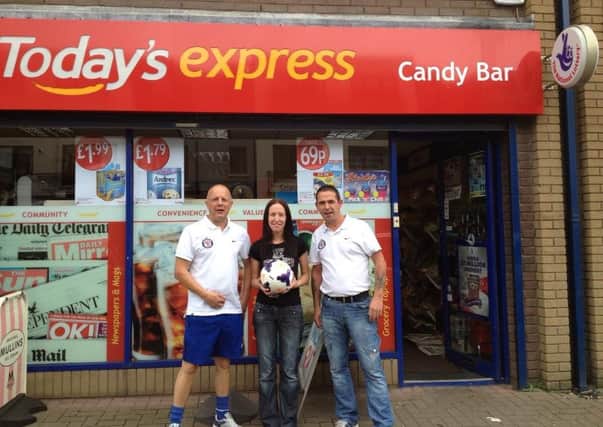 Southside Youths FC officials Tony Corrigan and Robin McIlhagga receive a sponsored matchball for the new season from the Candy Bar, Harryville.