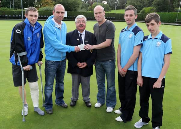 Ballymena Bowling Club president Nigel Robinson presents a sponsorship cheque to George Graham of Seven Towers FC while looking on are Aaron Gordon and Adam Gordon, George Graham and Ballymena Bowling secretary Joe McKeown. INBT 36-185CS