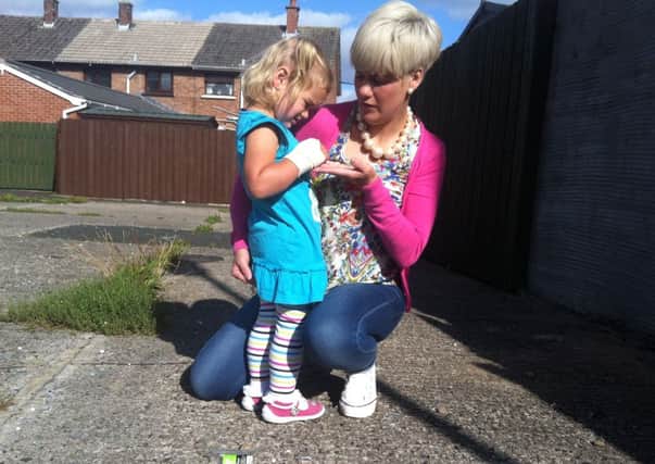 Clare Toman with her two year old daughter Daisy who cut her hand on glass strewn on waste ground INLM36 023