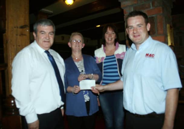 Johnny Hanna presents a cheque for almost £2000 to Dorothy Hill, committee member of the Ballymoney branch of Cancer Research UK at Ballymoney Rugby Club. Also included are other committee members, Mervyn Ferris and Debbie Tutty.INBM36-13 323L