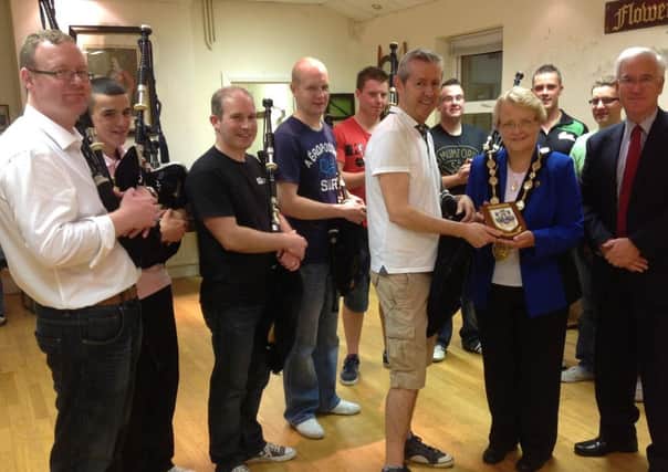 The Mayor, Councillor Margaret Tolerton, presents Pipe Major Richard Parkes, MBE, with a Lisburn City Council plaque.  Also pictured are band members and Lisburn City Councils Director of Corporate Services, Mr Adrian Donaldson.