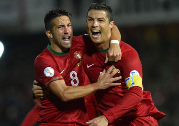 Cristiano Ronaldo celebrates with team-mate Joao Moutinho after he fired home his third goal, during Portugal's 4-2 win over Northern Ireland.
