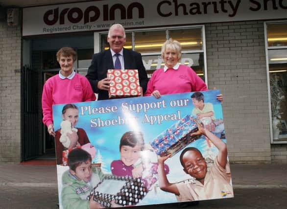 Alderman Bill Kennedy helps launch the Drop Inn Ministries annual shoebox appeal with the help of volunteers Maureen Pollock (left) and Edwina Chambers.INBM38-13 508L