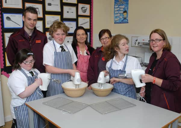 Castle Tower students Kimmi, Michael, Alanna, Home Economics teacher Mrs. R. McCaughan show off the baking equipment received from the Sainsburys Active Kids vouchers. Included are Sainsbury's staff Ross Finlay, Sadie Peachey and Diane Huey. INBT38-209AC