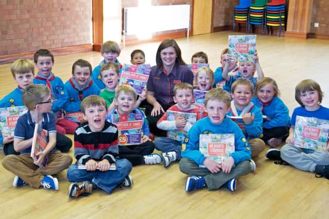 Anne Patterson from Sainsbury's presents kids from 4th Carrick Beavers with their own "Bumper Scrapbook" as part of the retailer's work in the local community. INCT 38-417-RM