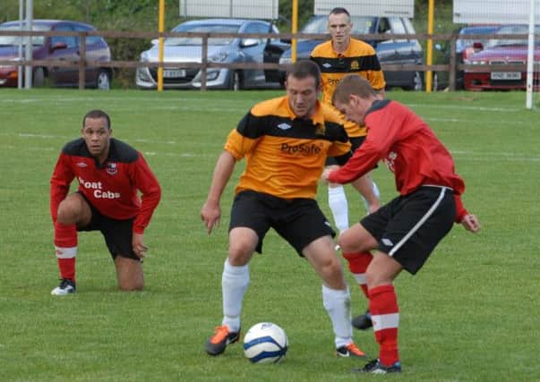 Barn United's Gary McKee tries to win back possession against Dundonald.