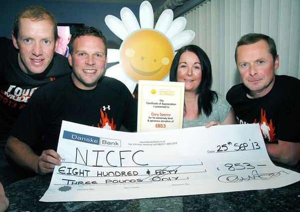 Kathy Tang, Northern Ireland Cancer Fund for Children; receives a £853 cheque from William Fleck, Gary Spence and Adrain Aicken who took part in the "Tough Mudder" 12 mile race. INBT 40-824H