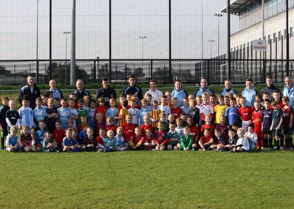 Some of the participants at the Ballymena United Youth Academy mini soccer coaching pictured with Ballymena United players Jamie Davidson and Mark Surgenor, and head of youth development Joe McCall. INBT40-231AC
