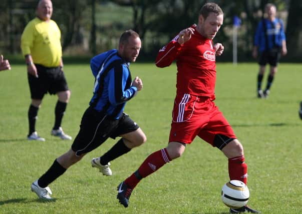 A Clough Rangers athletic player sprints in to tackle his Waveney Strollers opponent. INBT40-246AC