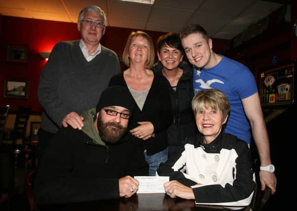 Paul Bullock, of the BT & PO Blues Club, presents a cheque for £1000 to Maureen Baw of NI Chest, Heart and Stroke, as looking on are Gabriel O'Hagan, Aileen McCandless, Sharron Gordon and Aaron Gordon. The money was raised from a recent charity night organised by the BT Blues Club, in memory of the late John Marks, former chairman of the BT & PO Club. INBT40-205AC