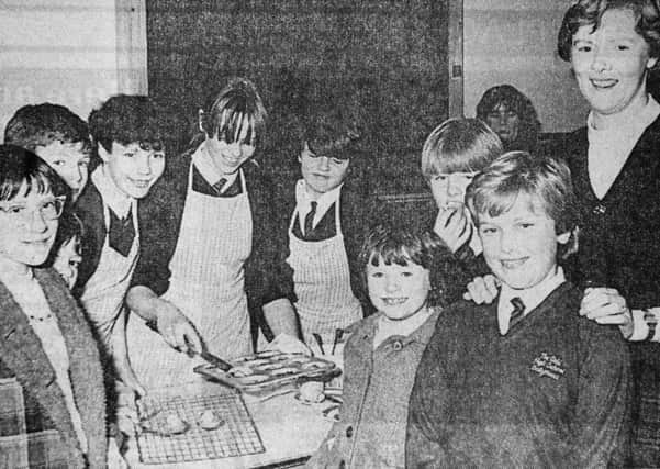 1985 - Mrs. Beth McKee (far right), home economics teacher at Ballymena Girls' High School, accompanies some of the visitors to the school as they sample some of the pupils cooking at their open night. INBT41-756F