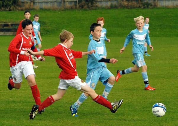 A Ballymena United under-13 player skips past the challenge of a Carniny opponent during Saturday's match at the Showgrounds. INBT 42-854H