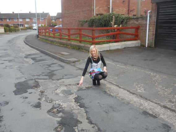 Councillor Carla Lockhart surveys the state of the road surface at Glenfield Road.