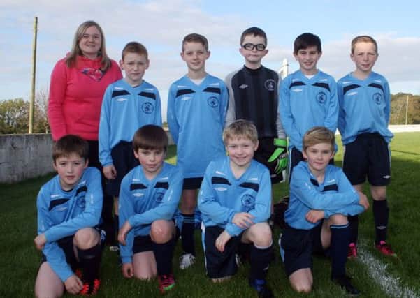 Model Primary School teacher, Rebecca Hall, with her young footballers who took part in a competition solely for Integrated Primary Schools at Ballymoney Showgrounds.INBM43-13 100L