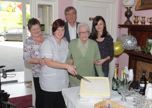 Ella Hamilton, longest staying resident at Colebrooke House care home, cuts the cake to celebrate the 25th anniversary. With her are Jennifer Woodside, Caroline Lockwood, Charlie Rowan and Anne Marie Rowan. INLT 42-326-PR
