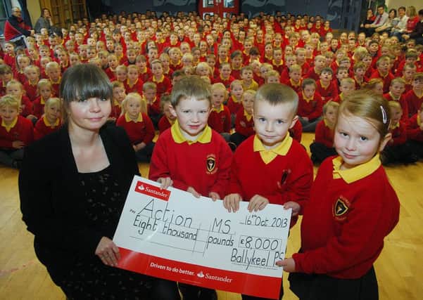 Action Cancer girl Angela Hampton recieves a £8,000 cheque from Ballykeel Primary School pupils Rhyanna, Jamie and Tyler proceeds of a sponsored walk the school did. INBT 43-801H