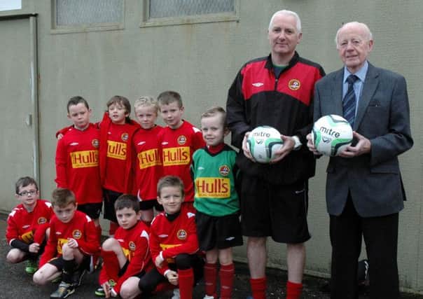 Billy Smyth of Eurown Paints presents sponsored Match balls to Carniny Youth Under 9 manager Niall Greer