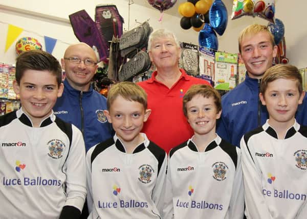 Lisburn based Luce Balloons is the shirt sponsor for Lisburn Distillery U-12s. Pictured behind U12 players are Eric Patton of Luce Balloons (centre) and U12 coaches, Colin Scott (left) and Johnny Scott (right). Picture David Hunter.
