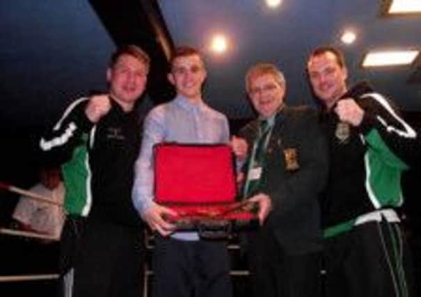 Enda Kennedy receives the Boxer of the Tournament belt from Eugene Duffy, secretary of the Ulster Boxing Council, after last week's Ulster intermediate championship success. Also included are All Saints coaches TJ and Dermot Hamill.