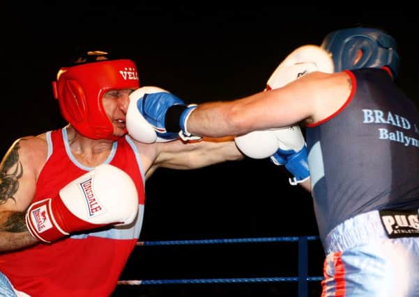 Bert Purdy cringes as he receives a blow from Seamus Hastings during the Braid ABC white collar fight night, raising  money for Cancer Focus. INBT45-217AC
