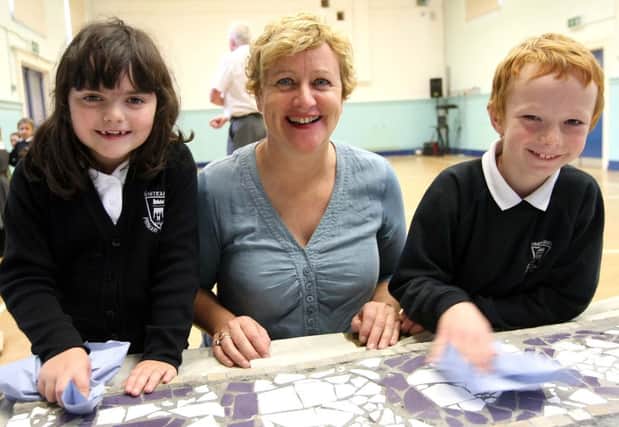 Glengormley artist Angela Ginn with Whiteabbey Primary School pupils Nicola Donald and Tim Swarbrick, working on the 'Our Beautiful World' mosaic. INNT 42-023-FP