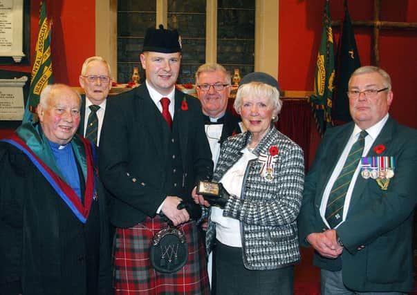 Photographed last week in St Saviour's Church at the UDR Service of Remembrance was piper Ashley McMichael who received a special presentation from County Antrim Lord Lft. Joan Christie watched by Rt Rev Robert Coulter, Charlie McCartney, chairman UDR Association; Rev Ian McGowan and Ken Murphy, UDR Association. INBT 46-803H