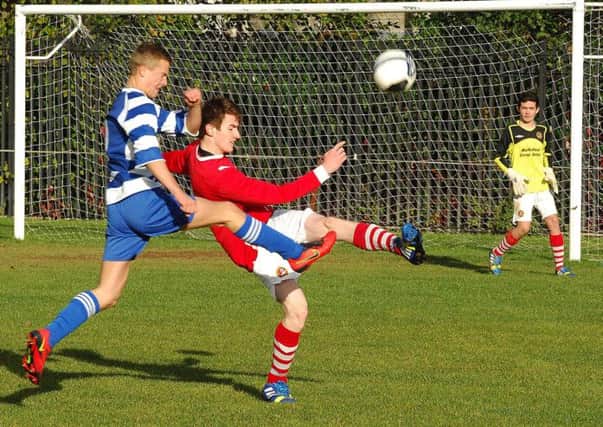 A Carniny Youth under-15 player makes an important intervention to deny a Northend United Youth opponent during Saturday's National League 'derby' match at the Showgrounds. INBT 46-861H