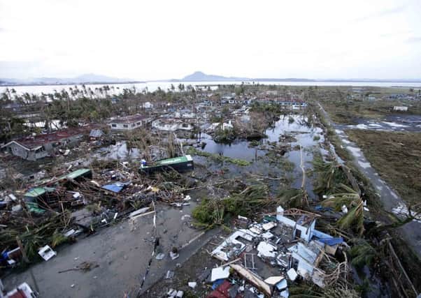 Tacloban city is covered by debris Saturday, Nov. 9, 2013 after powerful Typhoon Haiyan hit the city in Leyte province, central Philippines. Rescuers in the central Philippines counted at least 100 people dead and many more injured Saturday, a day after one of the most powerful typhoons on record ripped through the region, wiping away buildings and leveling seaside homes with massive storm surges.(AP Photo/Bullit Marquez)