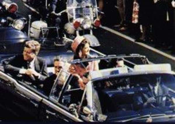 President Kennedy's limousine makes its way through Dealey Plaza in Dallas just seconds before he was assassinated by a gunman on November 22, 1963.