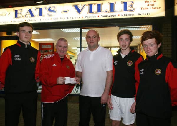 George McKay, proprietor of Eats-Ville, presents a sponsorship cheque to Billy O'Flaherty of Carniny Youth FC. Included are players Matthew Shevlin, Adam Mairs and Joe McCann. INBT47-228AC