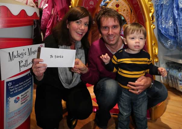 Portadown Times regional editor Alistair Bushe and wife Kelly prepare to post a letter to Santa for son Jacob at the Disney store.