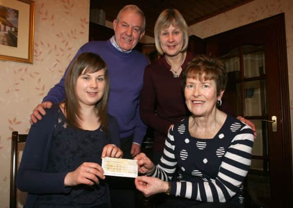 Catherine Hill presents a cheque for £1333.75 to Anna McClean of Parkinsons Ballymena and District Branch, raised from a barbeque organised by Catherine. Included is James McClean and Valerie Hill. INBT48-223AC