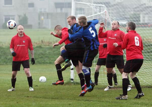 Glenravel FC challenge their Woodside opponents to win this header. INBT48-259AC
