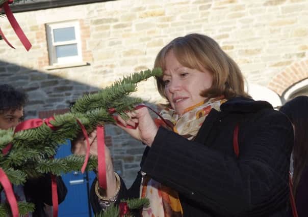 Baroness Smith of Basildon ties a red ribbon to the tree at the opening Foyle Women's Aid Ashleywood House on Friday. INLS4813-113KM