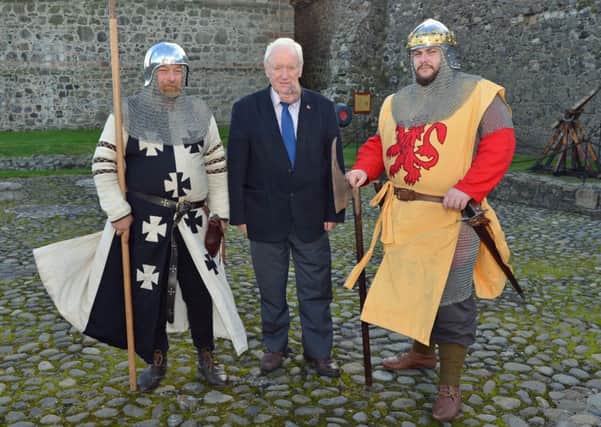 Attending the launch of Saturday's St Andrew's Day event at Carrickfergus Castle are Tom Scott (centre), chairman of the Ulster Scots Agecy with George Logan and Andy Mattison from Living History Ireland. INCT 46-013-PSB