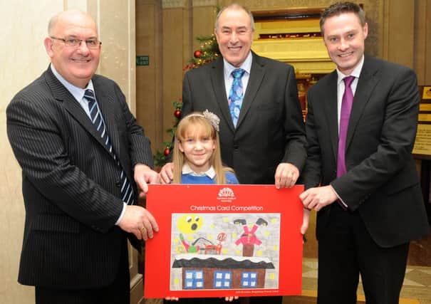 L-R: The Speaker of the Northern Ireland Assembly William Hay MLA, Principal Deputy Speaker Mitchel McLaughlin MLA and Paul Frew MLA pictured with Jodie Kernohan from Broughshane Primary School, Ballymena who was highly commended for her entry to the Northern Ireland Assembly Christmas Card Competition