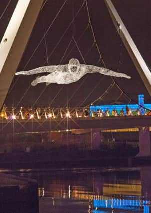 A figure is suspended over teh Peace Bridge during  Lumiere Derry~Londonderry