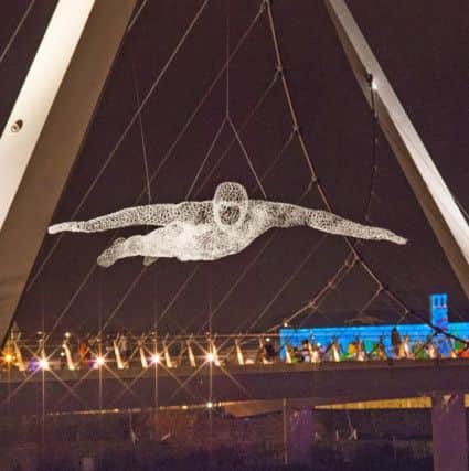 A figure is suspended over teh Peace Bridge during  Lumiere Derry~Londonderry