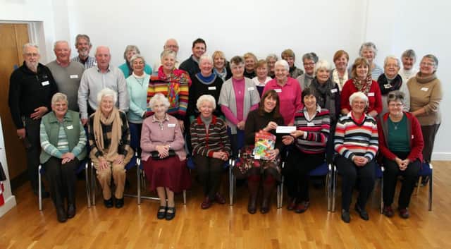 Marie-Louise McClarey, fundraising manager with The Corrymeela Community, is presented with money raised through collections from Eleanor Duff, chairperson Causeway Coast Peace Group. Included are members of the Causeway Coast Peace Group at a meeting held in Portballintrae Village Hall. INCR47-17PL