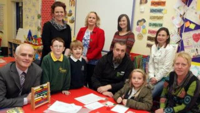 TOGETHER. Pictured at the Leaney PS on Wednesday are Principal Vivien Moorhouse, Teacher Miss Campbell,  (Leaney Maths Co-ordinator) Principal of St Brigid's PS Mr Malachy Conlon, Teacher Miss Cambell (St Brigid's Maths Co-ordinator), parents and pupils from both schools.INBM49-13 002SC.