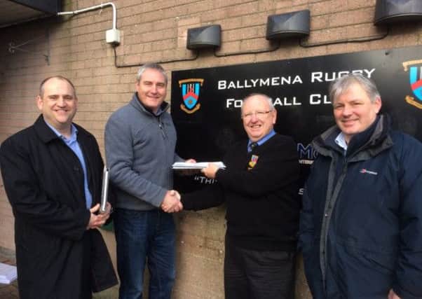 Mark Jackson of main contractors P&L Electrics hands over the documentation for the Eaton Park floodlighting project to Ballymena Rugby Club chairman Bill Wallace. Also included are Stuart Kyle of White Young and Green, consulting  engineers, and Ollie Smith, Ballymena RFC club member who advised and managed the project for the club.
