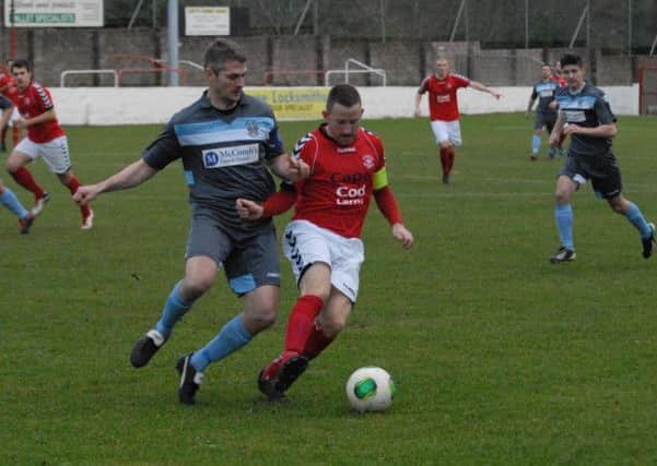 Larne captain Paul Maguire fends off his Lisburn Distillery opponent in last weekend's 1-0 win at Inver Park. Photo: Peter Rippon