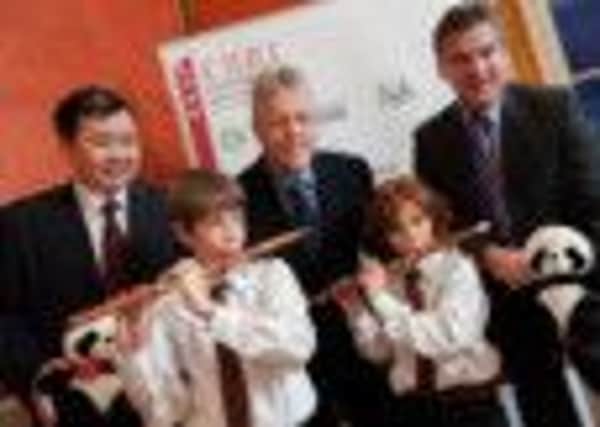 First Minister Peter Robinson is pictured with Coleraine pupils from Millburn PS  Myles Reilly and Rafferty Mackay  who both played Chinese flute to a VIP audience at the Stormont launch of Ulster's Confucius Classroom Hubs. Also pictured are Professor Xiang Xianzhi, President of Hubei Normal University (HBNU) and Professor Richard Barnett, Vice Chancellor, University of Ulster. INCR50-103S