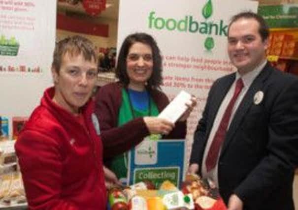 BANK ON IT. Pictured with some items at the foodbank at Tesco on Friday are Tesco Community Champion Audey Moore, Causeway Food Bank Volunteer Sue Gibson and Tesco Customer Services Manager Aidan McGarry.CR49-114SC.