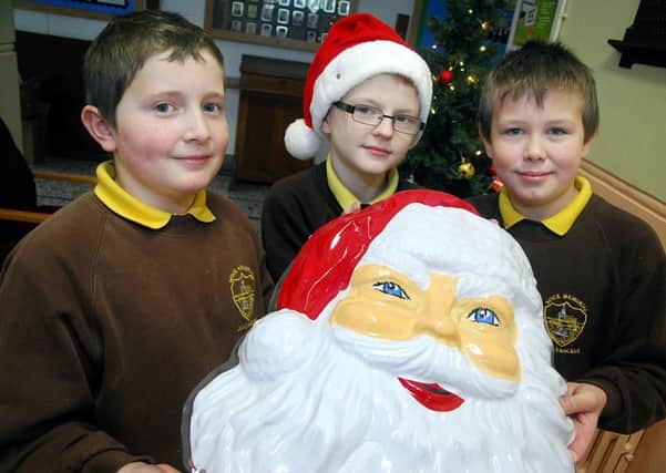 "HO HO HO" go Buick Primary School pupils Robert, Gary and Gareth who were ready to promote the schools forth coming Christmas Fayre on Friday 13th December at 2pm. INBT 50-803H